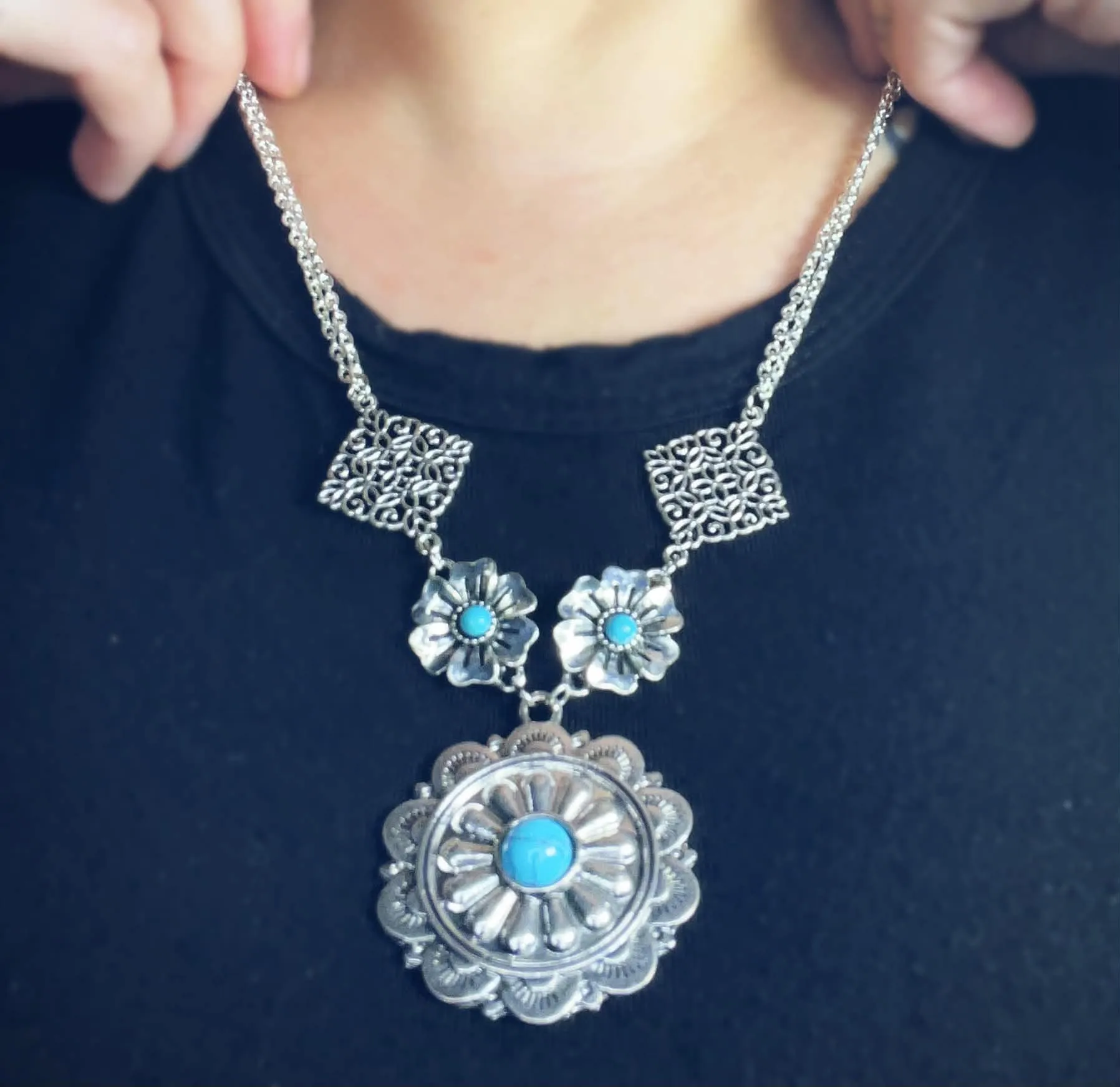 Silver and turquoise concho necklace being worn